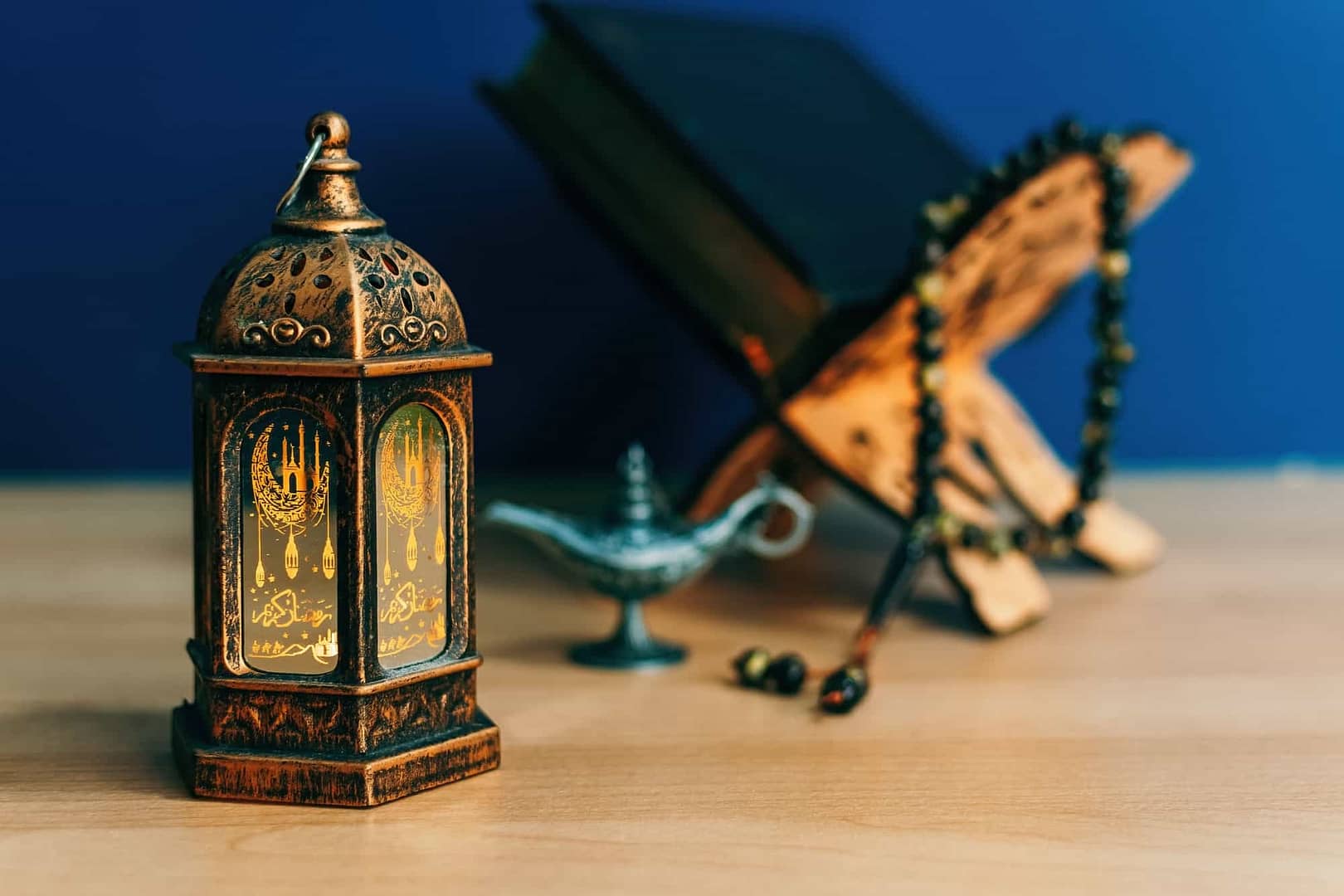 Lantern, religious book and lamp on wooden background concept of Islamic Ramadan holiday
